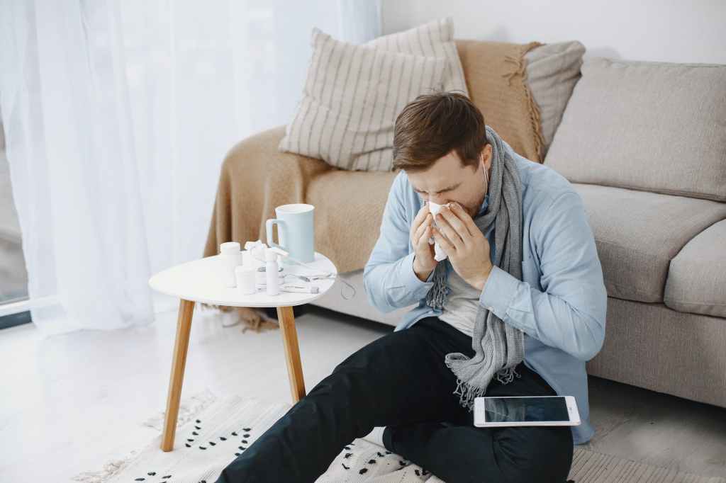 A sick man wiping his nose with tissue 